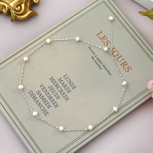 Elegant freshwater pearl necklace on a silver chain displayed on a vintage book