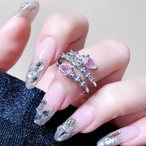 Macro view of stacked silver rings with pink pear-cut zircon and baguette stones