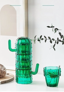 Detail of stackable cactus-shaped green glass cups with textured dots and side handles