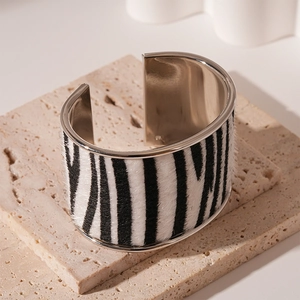 Detailed view of zebra print flocking leather bangle with silver metallic inner edge