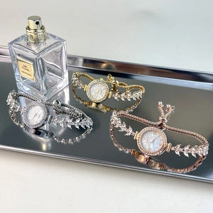 Detailed close-up of quartz watches in gold, silver, and rose gold with crystal accents