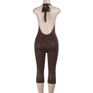 Detail of deep brown backless halter jumpsuit featuring golden metallic polka dot pattern