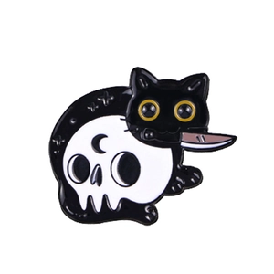 Detailed view of enamel cat pin with skull moon pattern and knife in mouth