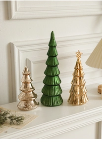 Close-up of elegant mercury glass Christmas trees in green and gold on a white mantel