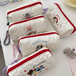 Detail of quilted pencil cases with cute puppy embroidery and colorful wrist straps