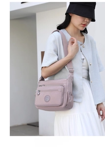 Close-up of lightweight purple nylon crossbody bag with multiple zipper pockets