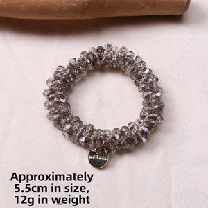 Detailed view of elastic crystal bead hair tie with Morava metal tag and dimensions