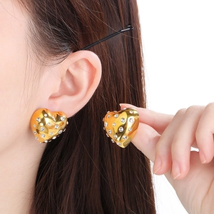 Boucles d'oreilles cœur vintage en or 18 carats avec strass portées par un mannequin