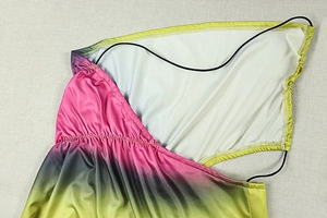 Detailed view of tricolor gradient knit dress with fine stitching and slim black neck straps