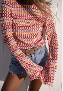 Détail d'un haut en crochet arc-en-ciel à manches évasées avec texture évidée ondulée