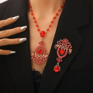 Close-up of vintage gold brooch with red crystals worn on a black professional suit