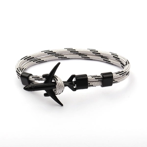 Detail shot of a black and white braided paracord bracelet with a black airplane charm