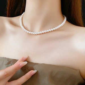 Gros plan d'un collier de perles blanches élégant et brillant sur un mannequin