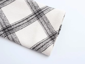 Close-up of the black and cream plaid wool fabric texture on this stylish jacket