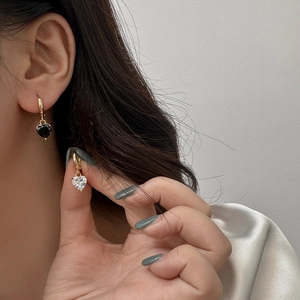 Golden heart drop earrings with black onyx and clear zircon stones in a minimalist style