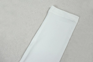 Macro detail of high-quality white fabric stitching on long sleeve cutout jumpsuit