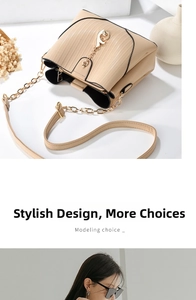 Detail of beige crossbody bag with vertical embossed texture and gold fish charm