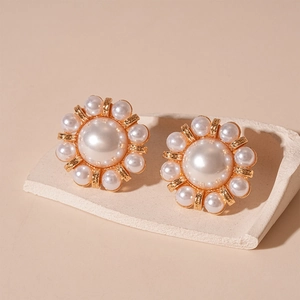 Detail of vintage flower stud earrings with faux pearls and golden alloy base