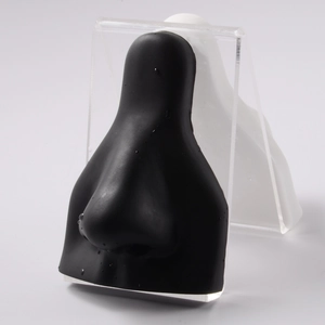 Macro shot of realistic black silicone nose model on clear acrylic display stand