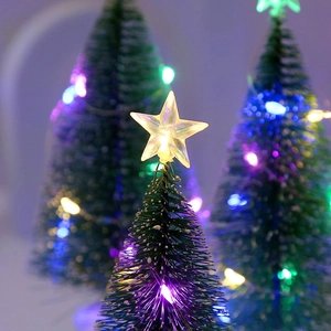 Close-up of a mini Christmas tree with glowing LED lights and a bright star topper