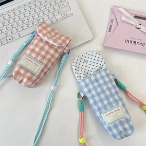 Detailed view of quilted cotton crossbody phone pouches in pink and blue plaid patterns