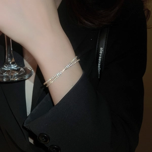 Détail d'un bracelet de tennis double couche en or avec zircon porté dans un cadre de luxe