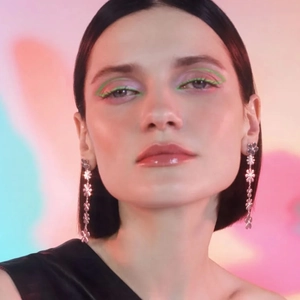 Gros plan de boucles d'oreilles pendantes marguerite en argent portées par un mannequin