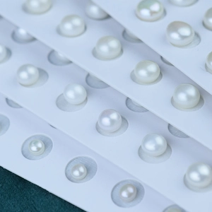 Macro shot of white freshwater pearls with high luster on display cards for jewelry DIY