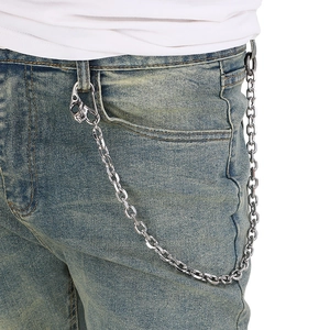 Detailed view of punk silver skull chain on blue denim jeans for street style fashion
