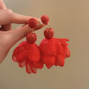 Close-up view of red raffia and layered chiffon flower petal drop earrings for women