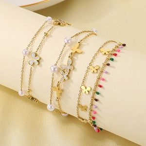 Detailed macro of gold-plated butterfly anklet with pearls on a display stand