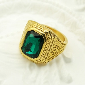 Detail of vintage gold ring featuring a green rectangular gemstone and embossed patterns