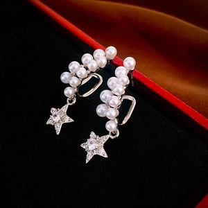 Close-up of vintage pearl star earrings in a jewelry box with sparkling zircon details
