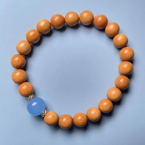 Detailed top view of sandalwood bead bracelet with blue lotus charm and crystal spacers