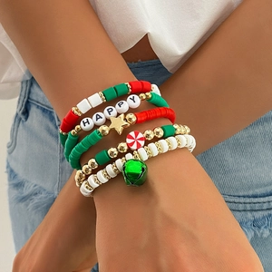 Close-up of stacked Christmas beaded bracelets with festive charms on a model's wrist