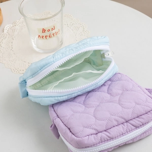 Detail of heart-quilted candy color makeup bags with internal mesh pocket and zipper
