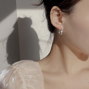 Detailed view of S925 sterling silver twisted double loop earrings worn on ear