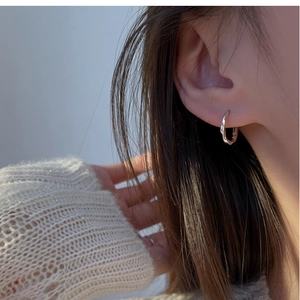 Close-up of minimalist S925 sterling silver hoop earrings worn for a sleek everyday look