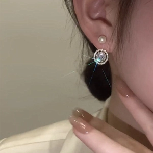 Boucles d'oreilles élégantes en perles et zircons plaquées or portées par un mannequin