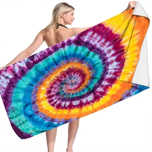 Detail showing colorful tie-dye microfiber beach towel with vibrant swirl patterns on a model