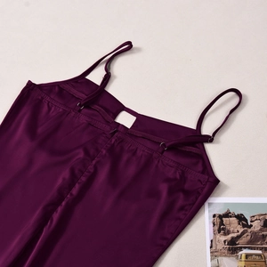 Detail of dark purple satin dress featuring adjustable straps and a sleek back zipper