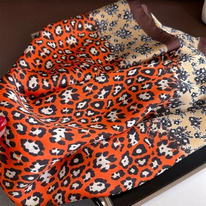 Detail of leopard print silk scarf with floral patterns and smooth satin texture