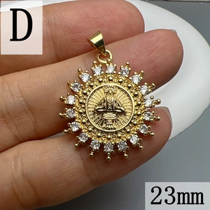 Detailed macro view of 23mm gold sunflower pendant with religious relief and white zirconias