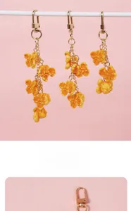 Close-up of realistic yellow PVC popcorn pendants with gold lobster clasps and chains