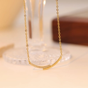 Elegant gold smile necklace with micro-pave cubic zirconia on a luxury display