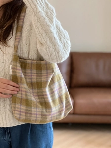 Gros plan du sac cabas en laine à carreaux jaune et violet avec étiquette blanche
