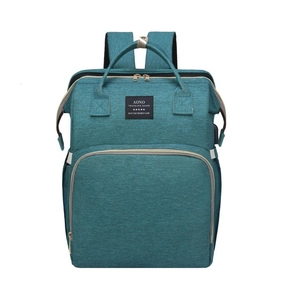 Detail of dark green multi-functional diaper backpack with front pocket and top handle