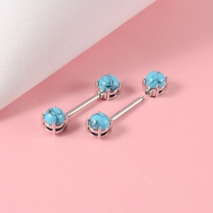 Detailed macro view of steel nipple barbells with turquoise inlay and claw setting