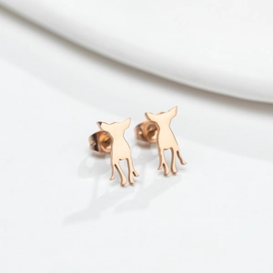 Chic rose gold puppy silhouette stud earrings with polished finish on white pedestal