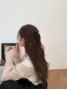 Barrette à cheveux élégante avec nœud en satin noir portée par un mannequin chic
